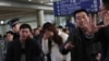 A relative (C, in white) of a passenger onboard Malaysia Airlines flight MH370, covers her face as she cries at the Beijing Capital International Airport in Beijing, March 8, 2014. 