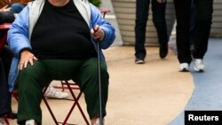 Seorang wanita yang mengalami kelebihan berat badan duduk di kursi di Times Square, New York, 8 Mei 2012 (foto: Lucas Jackson/REUTERS)