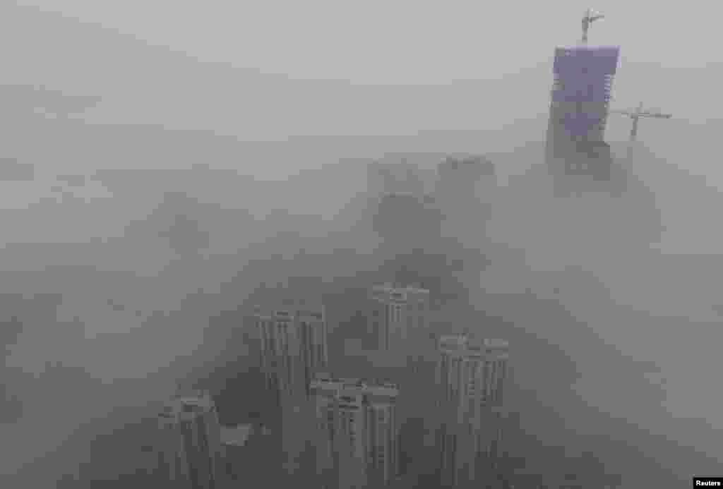 Buildings are seen shrouded in heavy haze at Qingdao development zone, Shandong province, Feb. 25, 2014.&nbsp;