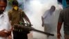 A municipal worker fumigates an area outside a train station to check the spread of mosquito-borne diseases in Mumbai, India, Sept. 3, 2016. 