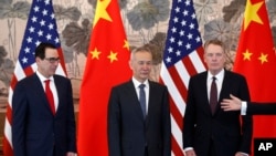 FILE - Chinese Vice Premier Liu He, center, U.S. Treasury Secretary Steven Mnuchin, left, and U.S. Trade Representative Robert Lighthizer, right, arrive for a group photo session after concluding their meeting in Beijing, May 1, 2019.