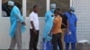In this photo taken on March 29, 2014, medical personnel at the emergency entrance of a hospital receive suspected Ebola virus patients in Conakry, Guinea.