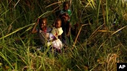 Children cross a swamp area to reach a registration area prior to a food distribution carried out by the United Nations World Food Programme (WFP) in Thonyor, Leer county, South Sudan, February 25, 2017. Picture taken February 25, 2017. 