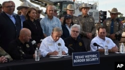 Gubernur Greg Abbott menandatangani tiga rancangan undang-undang di lokasi pembangunan tembok perbatasan di Brownsville, Texas, Senin, 18 Desember 2023. (AP/Valerie Gonzalez)