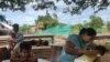 Lang Chanthoeun, 35, a villager in Kampong Thom province’s Krayea commune, looks after her daughter, who has been diagnosed with dengue fever, as she vomits while Lang Chanthoeun gives an interview to VOA, June 2019. (Sun Narin/VOA Khmer)