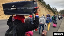 Venezuelan migrants walk along the Ecuadorean highway to Peru before new rules requiring they hold a valid passport kick in, at Tulcan, Ecuador, Aug. 21, 2018. 