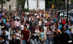 People spill into an avenue after a power outage in Caracas, Venezuela, March 7, 2019. A power outage left much of Venezuela in the dark Thursday evening in what appeared to be one of the largest blackouts in a country where power failures have become common.