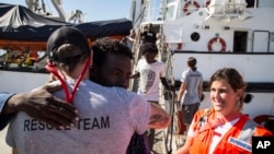 In this photo taken Thursday, Aug. 9, 2018, migrants disembark from the the Open Arms boat, in Algeciras, Spain, after being rescued off the coast of Libya in the early hours of the nigh of Thursday, Aug. 2, 2018. 