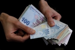 FILE PHOTO: A merchant counts Turkish lira banknotes at the Grand Bazaar in Istanbul, Turkey, March 29, 2019.