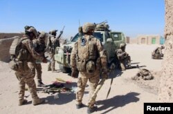 FILE - Afghan Special Forces prepare themselves for battle with the Taliban on the outskirts of Lashkar Gah capital of Helmand, Afghanistan, Oct. 10, 2016.