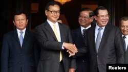 Cambodia's Prime Minister Hun Sen (2nd R) shakes hands with Sam Rainsy (2nd L), president of the Cambodia National Rescue Party (CNRP), after a meeting at the Senate in central Phnom Penh July 22, 2014. Sen and Rainsy met at the Senate in an attempt to solve the country's year-long political crisis after a disputed election. Seven members of parliament and an assistant, all members of CNRP, were ordered detained pending trial and taken to prison on charges of leading an insurrection, which carries a penalty of 20 to 30 years in prison, and incitement to violence. REUTERS/Stringer