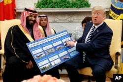 President Donald Trump shows a chart highlighting arms sales to Saudi Arabia during a meeting with Saudi Crown Prince Mohammed bin Salman in the Oval Office of the White House, Tuesday, March 20, 2018, in Washington.