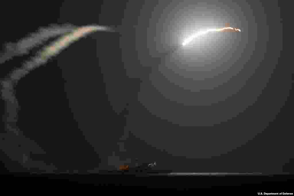 The guided-missile cruiser USS Philippine Sea (CG 58) launches a Tomahawk cruise missile as seen from the aircraft carrier USS George H.W. Bush (CVN 77). George H.W. Bush and Philippine Sea are part of Carrier Strike Group 2, supporting maritime security operations and theater security cooperation efforts in the U.S. 5th Fleet area of responsibility, Arabian Gulf, Sept. 23, 2014. (U.S. Navy photo by Mass Communication Specialist 1st Class Eric Garst/Released) 
