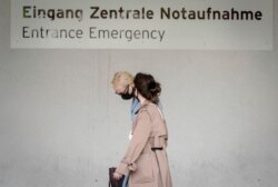 Alexei Navalny's wife Yulia, background, arrives at the Charite hospital in Berlin, Germany, Aug. 24, 2020.