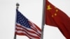 Bendera Amerika Serikat dan China berkibar di luar gedung perusahaan AS di Bejing, China, 21 Januari 2021. (Foto: Tingshu Wang/Reuters)