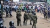FILE - Ugandan army soldiers and police officers stand in front of a crowd during an opposition protest in Kampala, Uganda, Aug. 31, 2018.