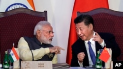  FILE - Indian Prime Minister Narendra Modi, left, talks with Chinese President Xi Jinping at the signing ceremony by foreign ministers during the BRICS summit in Goa, India, Oct. 16, 2016. 