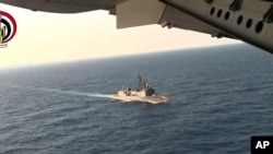 Un avion égyptien survole un navire égyptien sur la mer Méditerranée, durant la recherche de l’avion d’EgyptAir qui est écrasé après avoir disparu du radar tôt jeudi matin avec 66 personnes à bord au cours du vol 804 assurant la liaison Paris-Caire., 10 mai 2016. (Image fixe d’une vidéo du ministère égyptien de la Défense)
