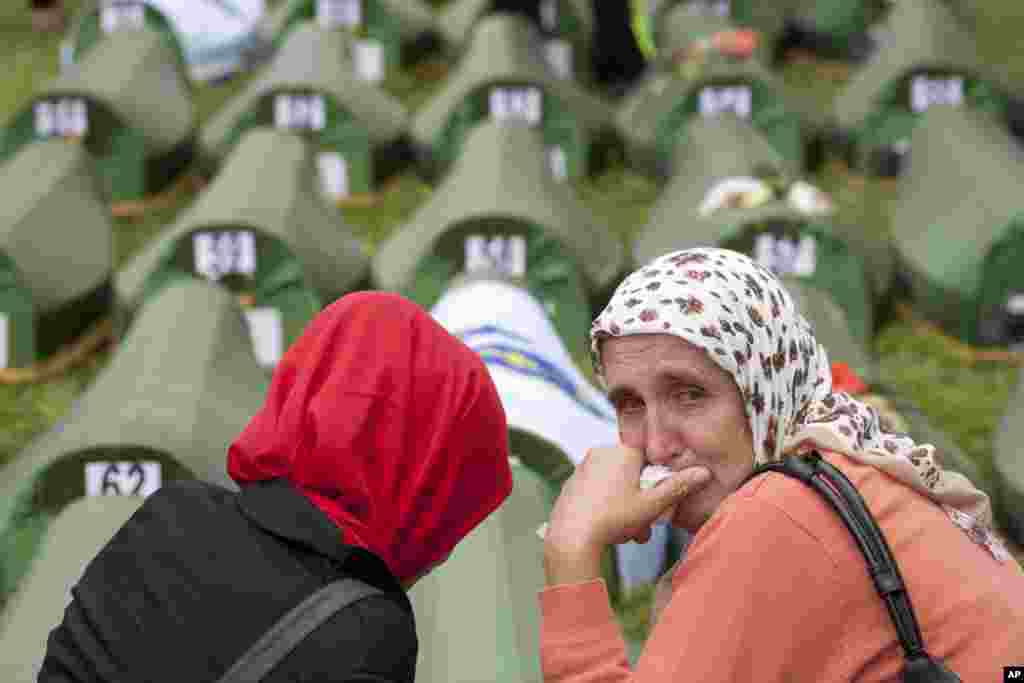 A Bosnian Muslim woman cries near coffins during a memorial ceremony and funeral in Srebrenica. Thousands of people gathered at the Potocari Memorial Center to remember the 175 victims of Europe&#39;s worst massacre since World War II.