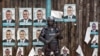 A Ugandan riot policeman blocks the gate of the party headquarters of opposition leader Kizza Besigye, shortly after raiding the premises for the second time in a week, in the capital Kampala, Feb. 22, 2016. 