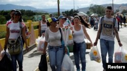 Warga Venezuela terlihat membawa kantong-kantong belanja saat mereka melewati perbatasan Kolombia-Venezuela di jempatan Simon Bolivar, setelah berbelanja dan memanfaatkan kesempatan setelah perbatasan di San Antonio del Táchira, Venezuela dibuka untuk sementara waktu.