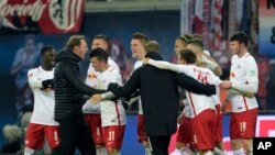 L'entraîneur de Leipzig, Ralph Hasenhuettl, à gauche, jubile avec son équipe après le coup de sifflet final du match de football de la Bundesliga entre le RB Leipzig et le FC Schalke 04 à Leipzig, en Allemagne, 3 décembre 2016. 