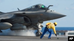 FILE - A photo released Nov. 23, 2015 by the French Army Communications Audiovisual office (ECPAD) shows a French army Rafale fighter jet taking off from the deck of France's aircraft carrier Charles De Gaulle, in the Mediterranean Sea. 