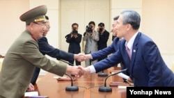 지난 2015년 8월 판문점에서 열린 남북 고위급 접촉에서 황병서 북한 군 총정치국장과 김관진 한국 국가안보실장, 김양건 북한 당 비서와 홍용표 한국 통일부장관이 각각 악수하고 있다.