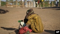 A South Sudanese refugee woman sits with her child at a refugee collection center in Palorinya, Uganda, Feb. 16, 2017.