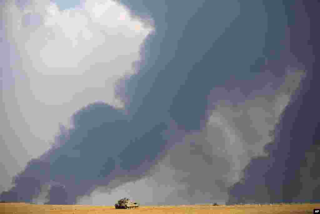 Israeli airstrikes pummel a wide range of targets in the Gaza Strip; an Israeli tank is seen here while heavy smoke rises from Gaza, July 22, 2014. 