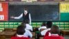 A teacher welcomes back students during a classroom lesson on day one of re-opening schools in Kampala, Uganda, Jan. 10, 2022.