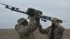 Para pilot sedang membawa drone di tempat latihan di wilayah Kyiv pada 23 Februari 2024, di tengah invasi Rusia ke Ukraina. (Foto: AFP)