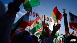 FILE - Protesters hold up a placard reading "Stop Execution in Iran" as they take part in a rally in support of anti-government demonstrations in Iran, in Berlin, Germany, Oct. 22, 2022.