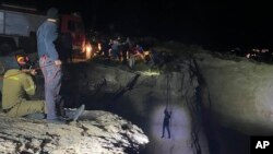 Authorities and local residents pull a migrant to safety after a sailboat carrying migrants sank near the island of Kythira, south of Athens, Greece, Oct. 6, 2022. 