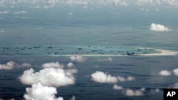 This photo taken through a window of a military plane shows China's apparent reclamation of Mischief Reef in the Spratly Islands in the South China Sea, May 11, 2015.