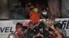 A paramedic (top) lowers one of the wounded survivor from the hijacked bus in Manila, 23 Aug 2010