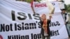 FILE - A Muslim woman releases a dove as a symbol of peace during a rally against the Islamic State group, in Jakarta, Indonesia.