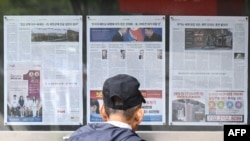 Čovjek gleda u novine postavljene u Seulu 21. oktobra 2024., u kojima se izvještava o odluci Sjeverne Koreje da rasporedi hiljade vojnika na ukrajinske linije fronta.