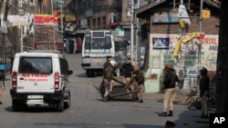 Indian policemen remove road blocks put up by protesters in Srinagar, Indian controlled Kashmir, Oct. 29, 2019.