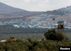FILE - A Turkish military armored vehicle patrols on the border line located opposite the Syrian town of Atimah, Idlib province, in this picture taken from Reyhanli, Hatay province, Turkey Oct. 10, 2017.