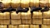 FILE - Guns are displayed on packs of confiscated methamphetamine during a news conference at police headquarters in Bangkok, Thailand, May 21, 2013. Police confiscated nearly 4.5 millions pills of methamphetamine as part of the raid.