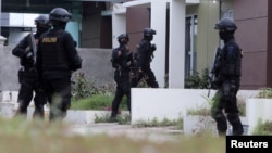 FILE - Indonesian anti-terror police from Detachment 88 are seen entering a building during a raid in Batam, Riau Islands, Indonesia.