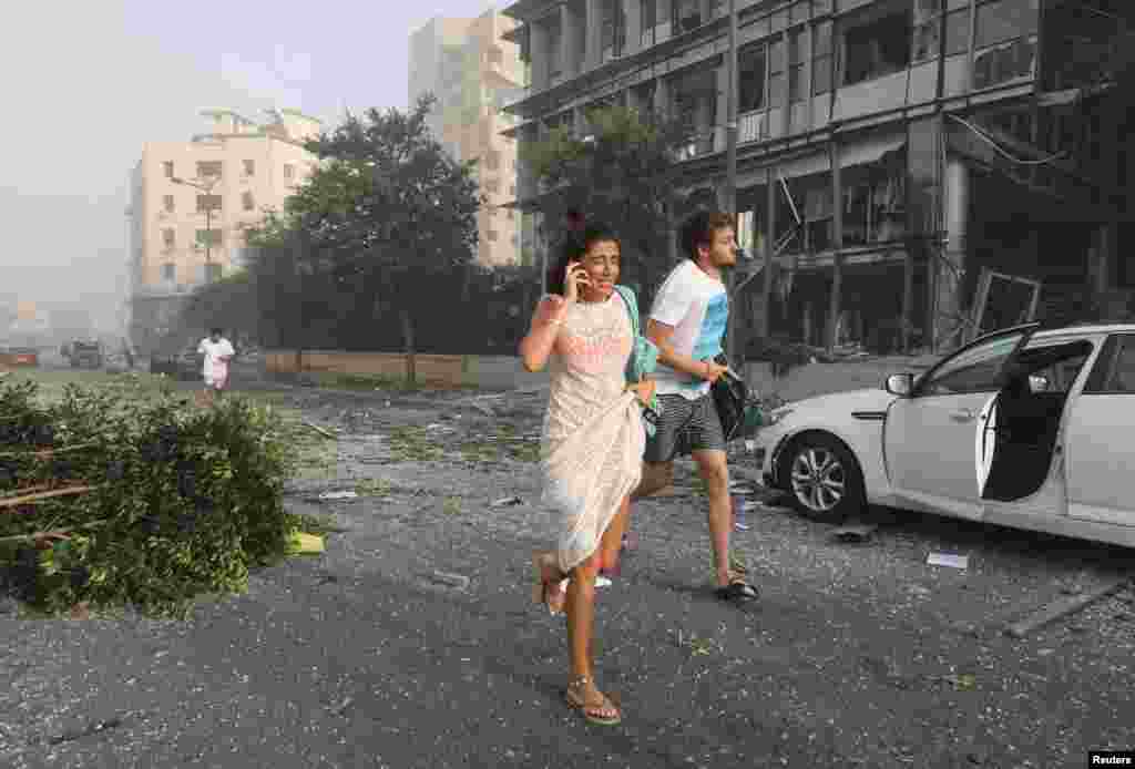 People run for cover following an explosion in Beirut&#39;s port area, Lebanon, Aug. 4, 2020.