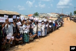 Rohingya refugees holding placards await the arrival of a U.N. Security Council team at the Kutupalong Rohingya refugee camp in Kutupalong, Bangladesh, April 29, 2018.