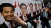 FILE - A protester raises a poster depicting outgoing Chief Executive Leung Chun-ying, left, with devil horns during a rally on the first day of 2017 in Hong Kong, Jan. 1, 2017.
