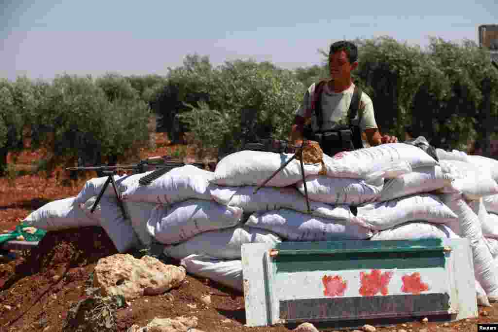 A Free Syrian Army member is seen behind sandbags at a checkpoint during a siege on the Kurdish city of Afrin, which is under the control of the Kurdistan Workers&#39; Party (PKK), in the Aleppo countryside June 30, 2013. 