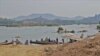FILE - Local villagers travel on the Mekong River near Nong Khai, Thailand. The Xayaburi dam upstream generateds hydropower for he region. (Steve Sandford/VOA)