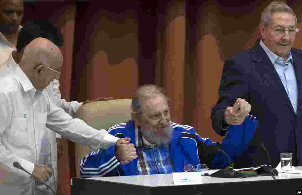 Fidel Castro assis tient la main de son frère, le président cubain Raúl Castro, à droite, et du deuxième secrétaire du Comité central, José Ramón Machado Ventura, quelques instants avant le chant de l&#39;hymne du Parti communiste lors des cérémonies de clôture du 7e Congrès de la Parti communiste cubain, à La Havane, Cuba, le mardi 19 avril 2016.