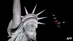 The Solar Impulse 2 aircraft flies over the Statue of Liberty before landing at JFK airport June 11, 2016 in New York. Solar Impulse 2 landed in New York early June 11, after flying by the Statue of Liberty at the end of the US portion of its bid to circl