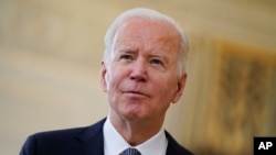 President Joe Biden listens to a reporter's question at the White House on Dec. 3, 2021.